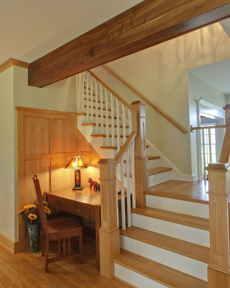 Foto di una grande scala a "L" american style con pedata in legno, alzata in legno e parapetto in legno