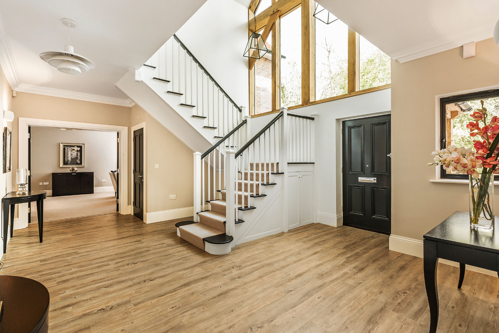 This is an example of a traditional wood u-shaped staircase in Surrey with painted wood risers.
