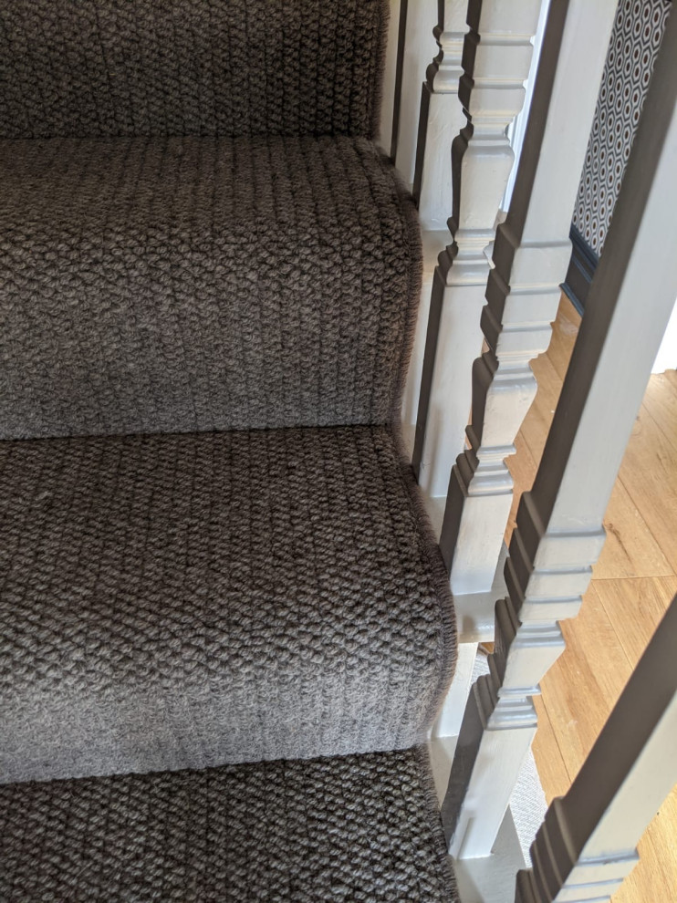 На фото: прямая лестница в стиле модернизм с ковровыми подступенками и деревянными перилами