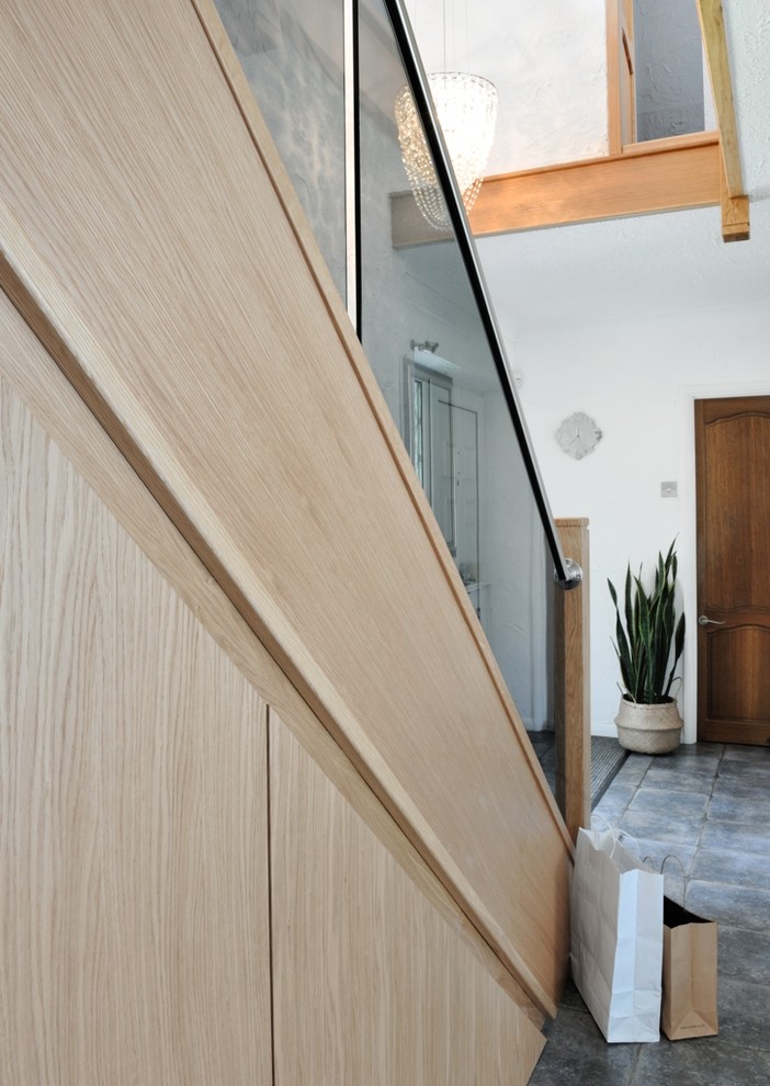 Diseño de escalera curva contemporánea de tamaño medio con escalones de vidrio, contrahuellas de madera y barandilla de metal