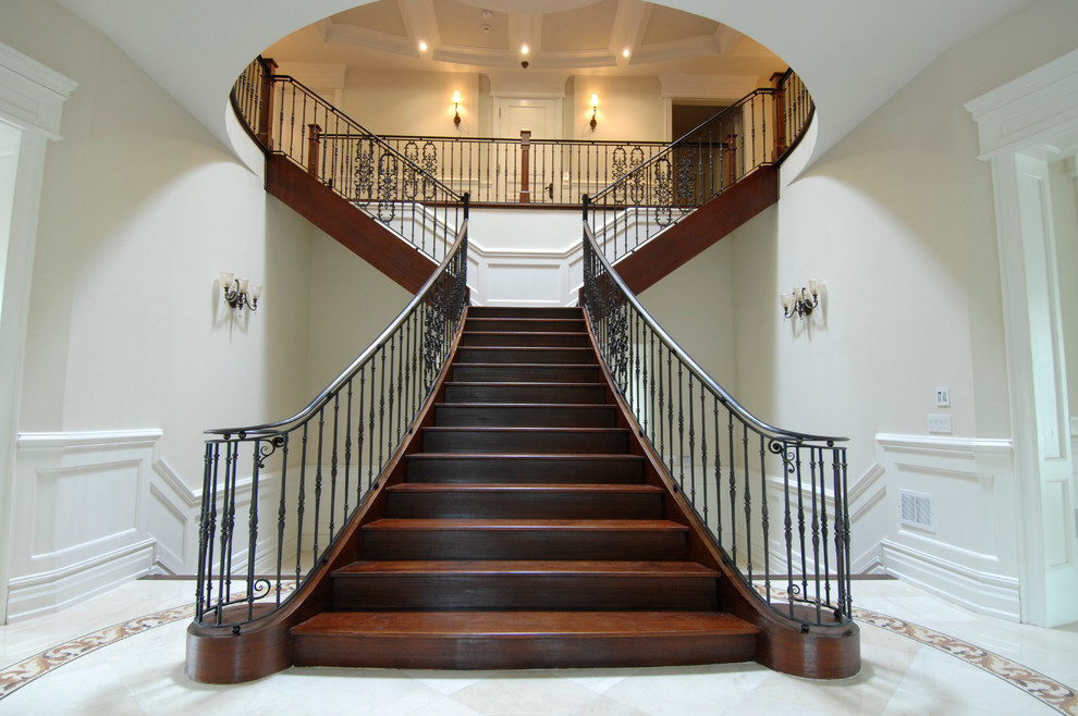This is an example of an expansive classic wood curved staircase in Toronto with wood risers.