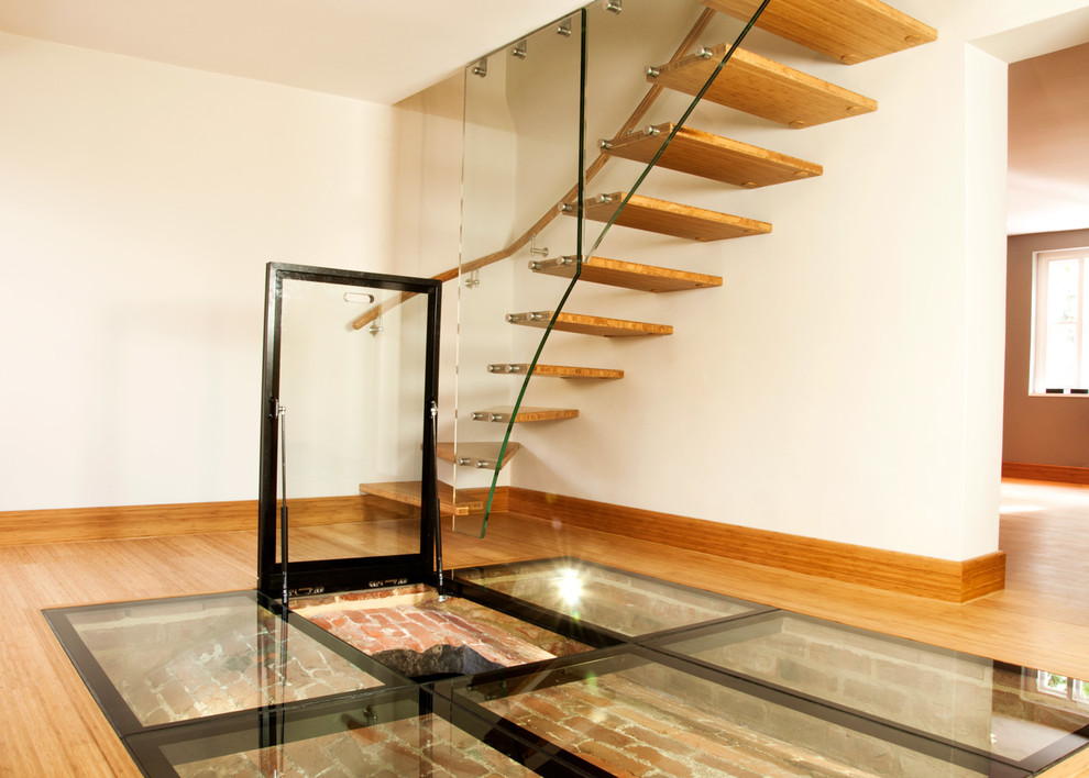 Photo of a small contemporary wood curved mixed railing staircase in Buckinghamshire with wood risers.