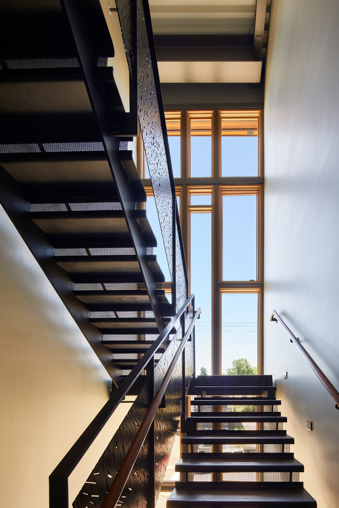 Example of a large minimalist metal u-shaped wood railing staircase design in Seattle with metal risers