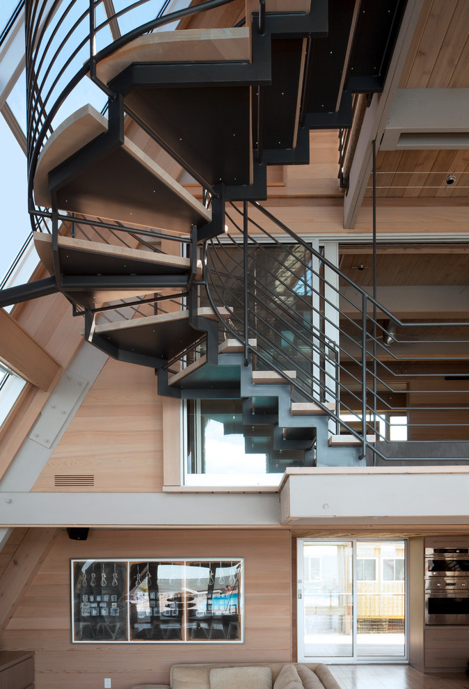 Foto de escalera en U actual extra grande sin contrahuella con escalones de madera y barandilla de metal