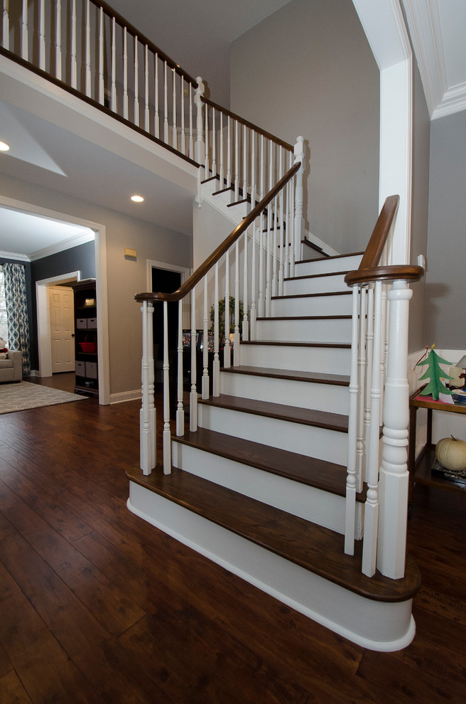 Идея дизайна: угловая лестница среднего размера в классическом стиле с деревянными ступенями, крашенными деревянными подступенками и деревянными перилами