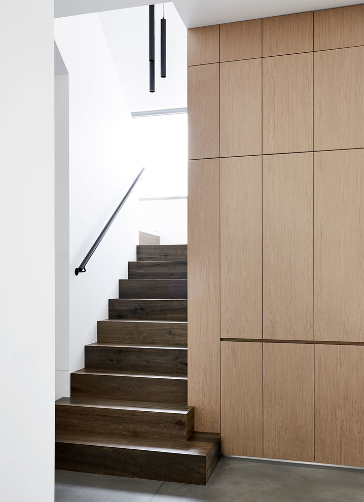 Idée de décoration pour un escalier design en U avec des marches en bois, des contremarches en bois et un garde-corps en métal.