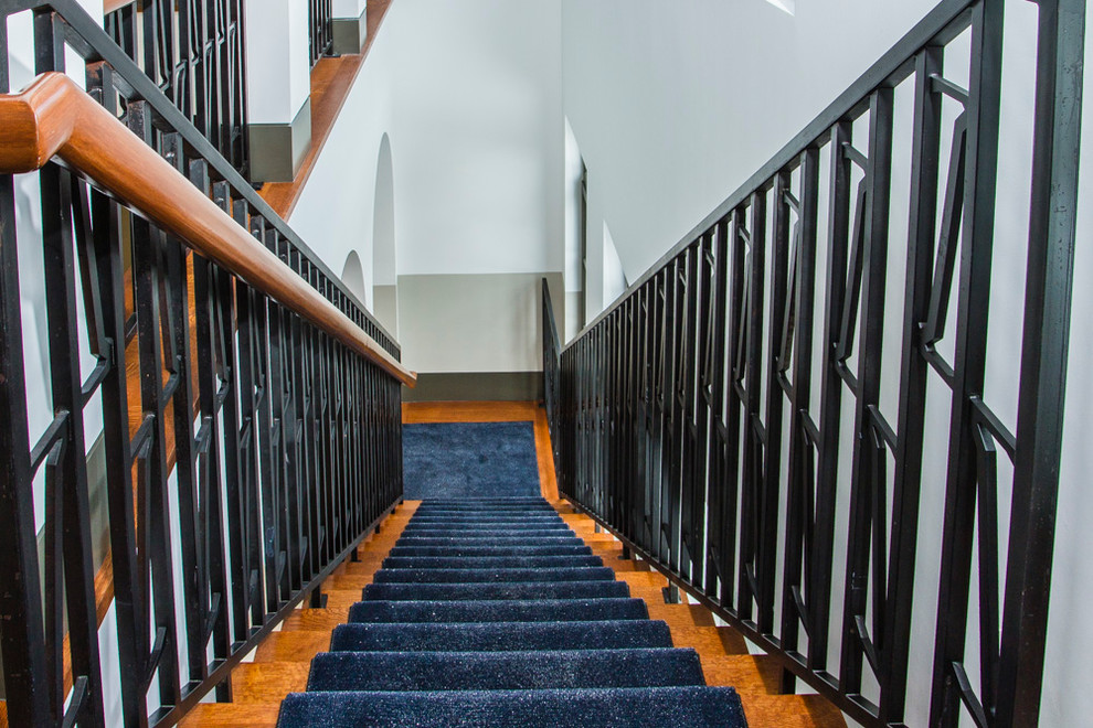 Foto de escalera recta clásica grande con escalones enmoquetados, contrahuellas enmoquetadas y barandilla de metal