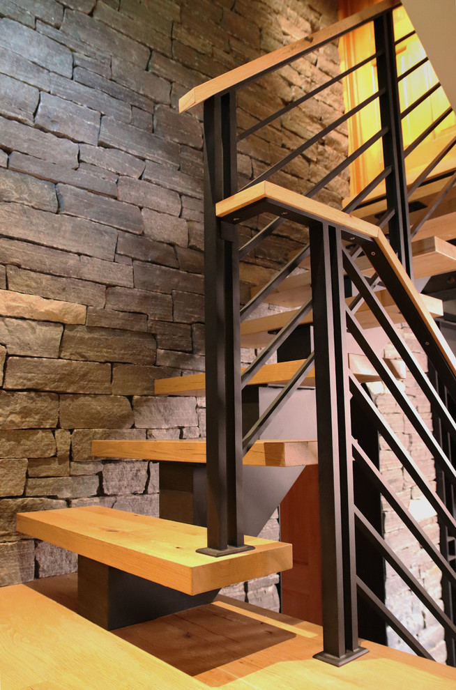 Photo of a medium sized rustic wood floating metal railing staircase in New York with open risers.