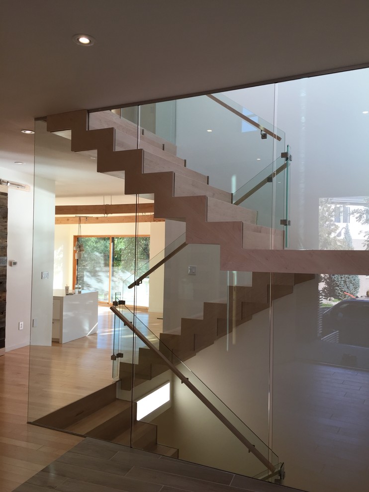 Foto de escalera en U minimalista de tamaño medio con escalones de madera y contrahuellas de madera