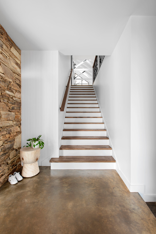 Foto de escalera recta contemporánea de tamaño medio con escalones de madera, contrahuellas de madera pintada, barandilla de metal y panelado