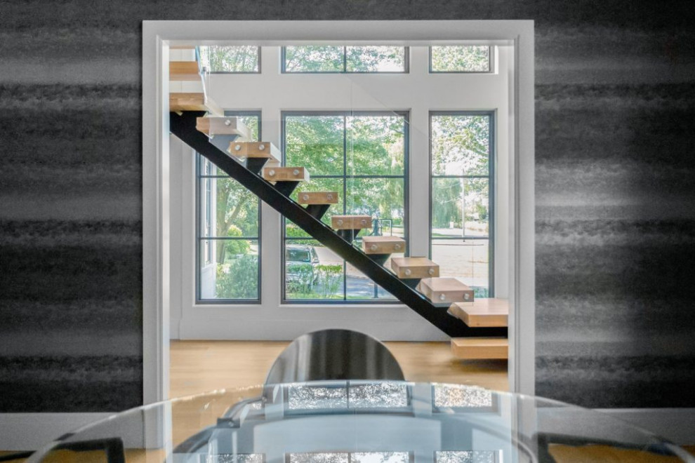 Пример оригинального дизайна: большая угловая лестница в стиле модернизм с деревянными ступенями и стеклянными перилами без подступенок