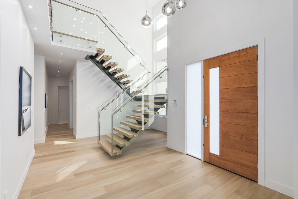 Mid-sized trendy wooden floating open and metal railing staircase photo in Vancouver