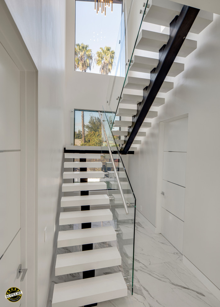 Inspiration for a large modern concrete u-shaped open and glass railing staircase remodel in Los Angeles