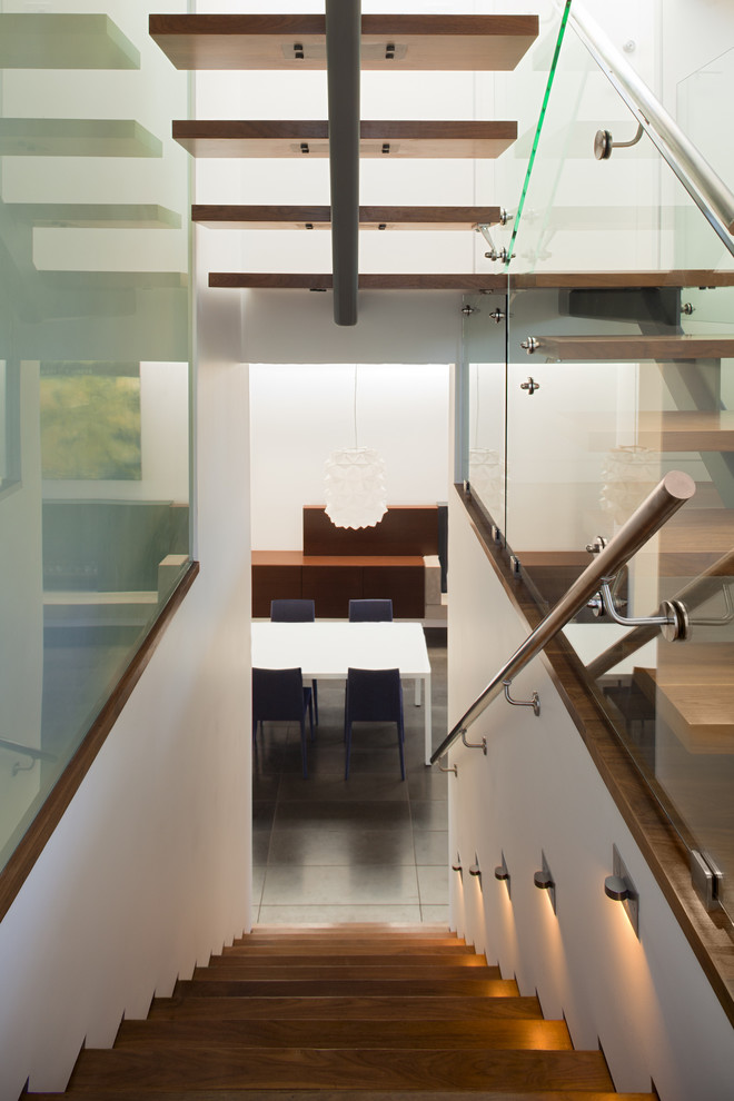 Пример оригинального дизайна: лестница в современном стиле с стеклянными перилами без подступенок