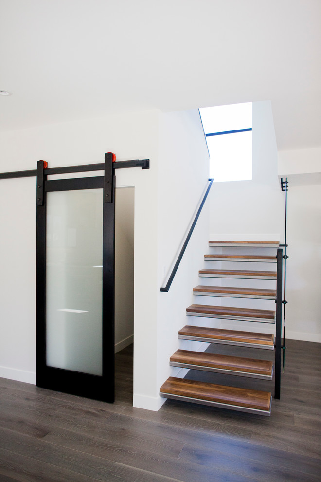Ejemplo de escalera suspendida minimalista sin contrahuella con escalones de metal