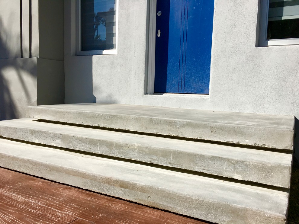На фото: большая бетонная лестница на больцах в стиле модернизм с бетонными ступенями