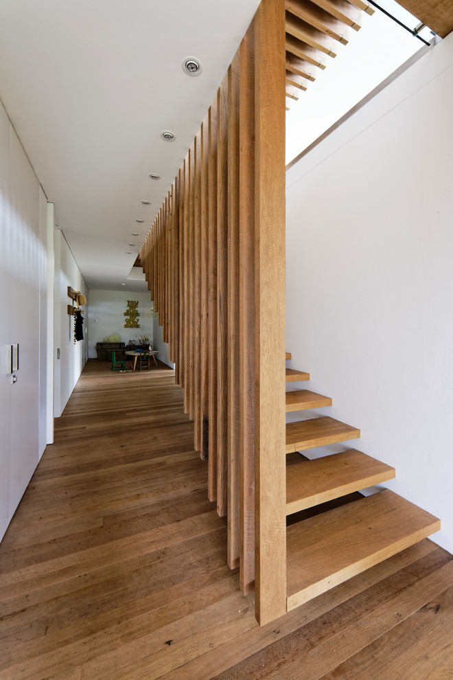 Свежая идея для дизайна: деревянная лестница на больцах, среднего размера в современном стиле с деревянными ступенями и деревянными перилами - отличное фото интерьера