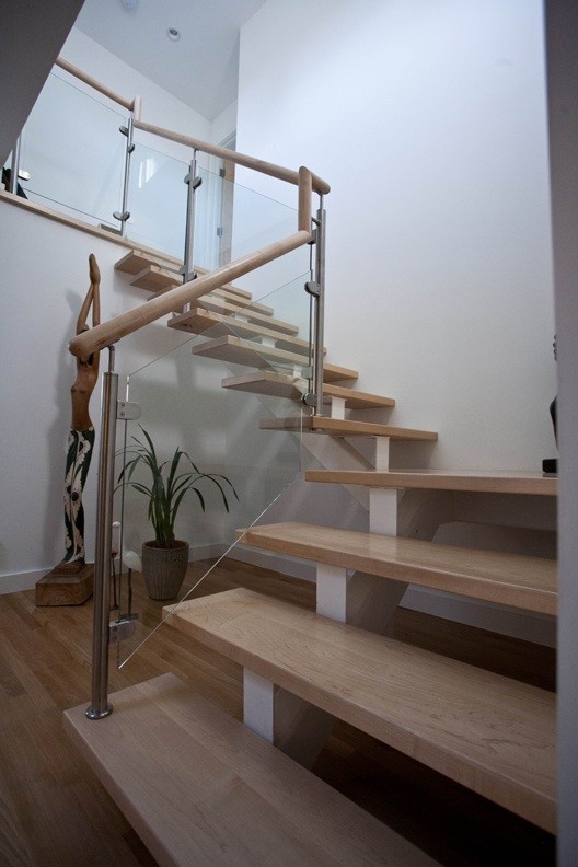 Ispirazione per una scala sospesa minimalista con pedata in legno e parapetto in legno