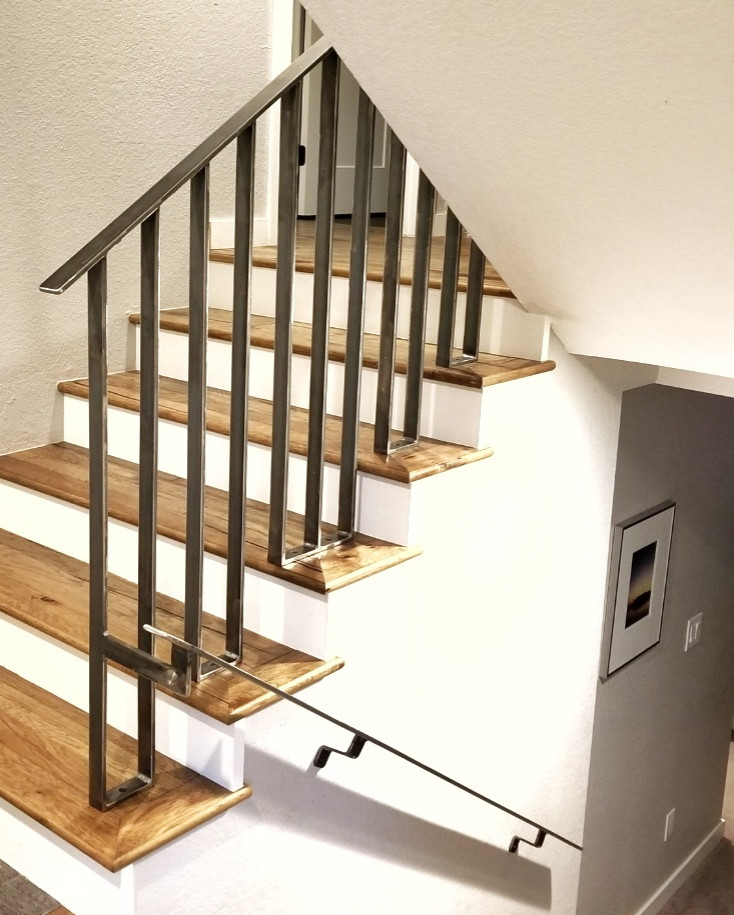 デンバーにあるラグジュアリーな中くらいな北欧スタイルのおしゃれな折り返し階段 (木の蹴込み板、金属の手すり) の写真