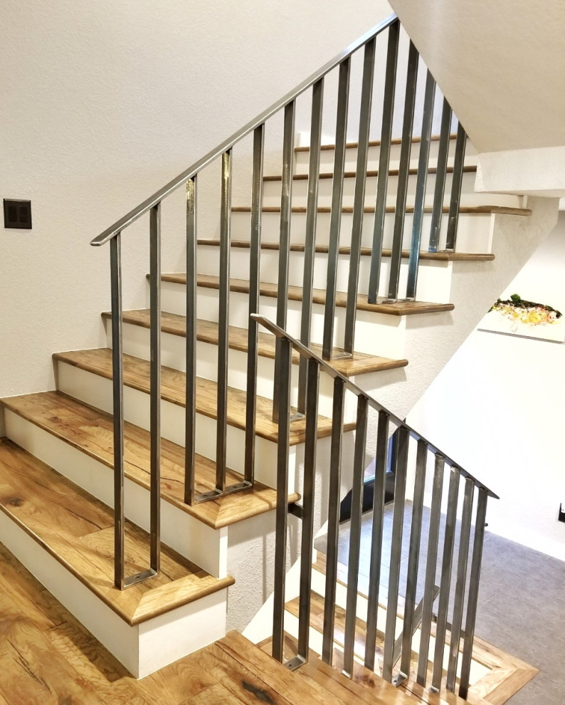 На фото: п-образная деревянная лестница среднего размера в скандинавском стиле с деревянными ступенями и металлическими перилами