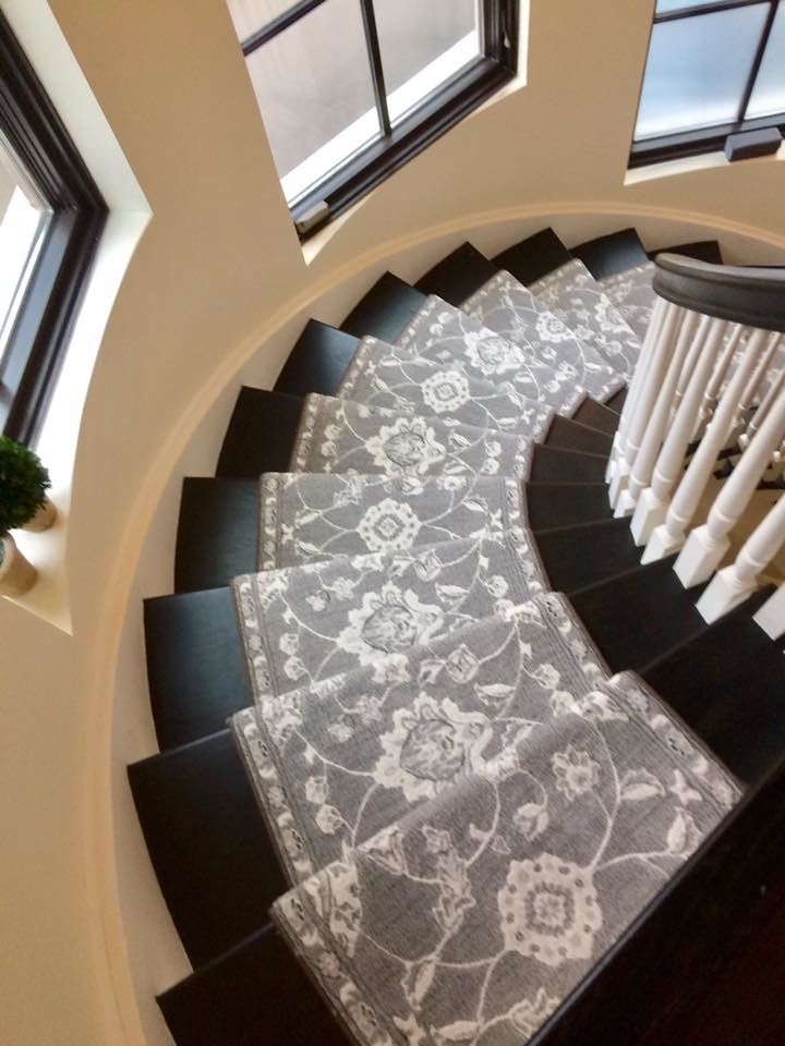 Large traditional wood curved staircase in New York with painted wood risers.