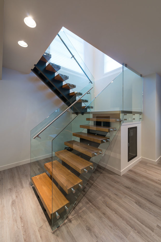 Réalisation d'un escalier sans contremarche minimaliste en U de taille moyenne avec des marches en bois, un garde-corps en métal et éclairage.