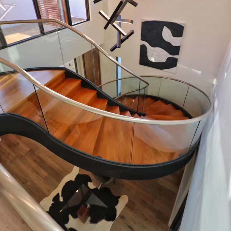 Idée de décoration pour un escalier courbe minimaliste de taille moyenne avec des marches en bois, des contremarches en bois et un garde-corps en verre.