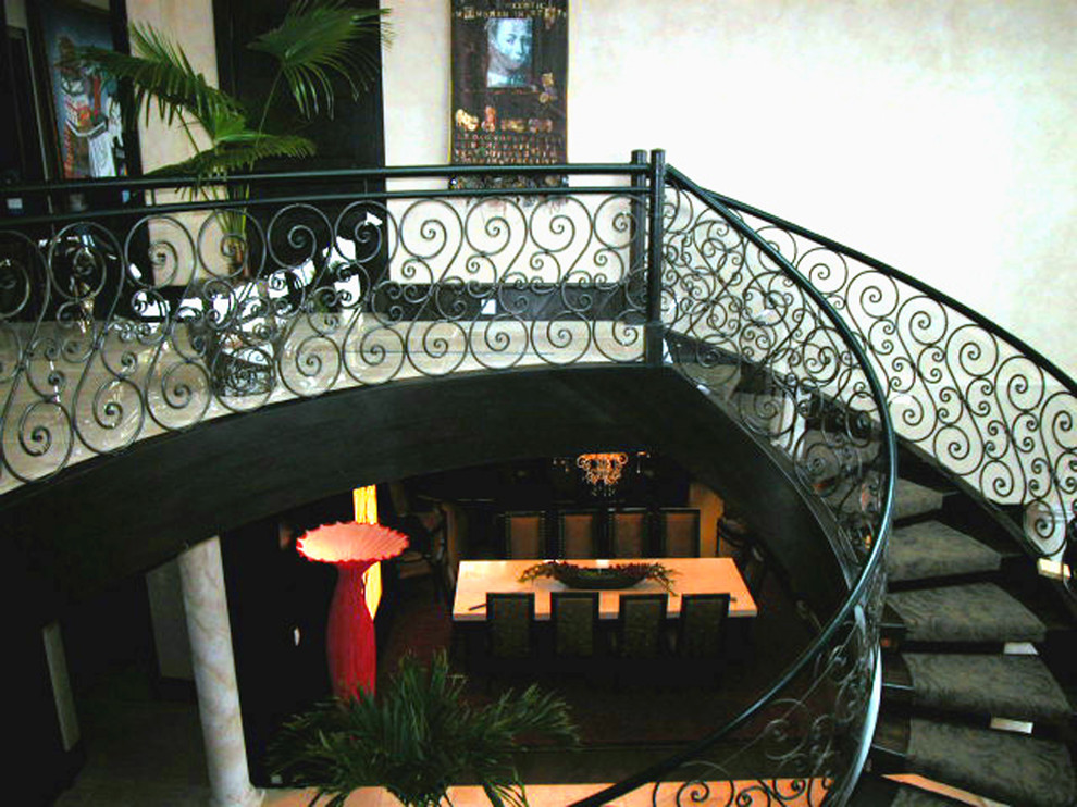 Источник вдохновения для домашнего уюта: огромная изогнутая лестница в средиземноморском стиле с ступенями с ковровым покрытием без подступенок