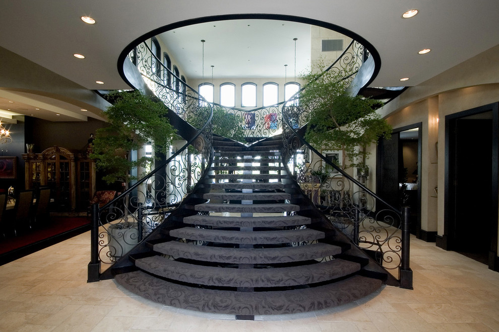 Huge tuscan carpeted curved open staircase photo in Other