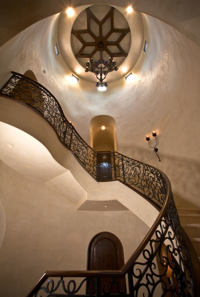На фото: большая изогнутая лестница в средиземноморском стиле с перилами из смешанных материалов с
