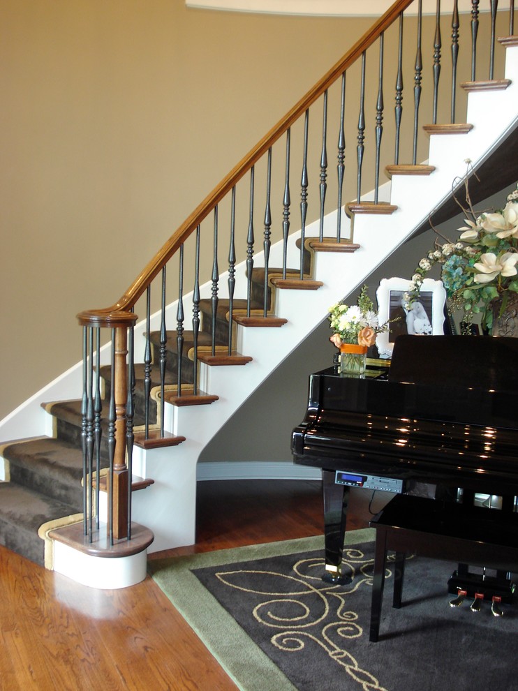 Inspiration for a mid-sized timeless wooden curved staircase remodel in Chicago with painted risers