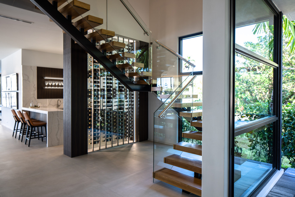 Imagen de escalera en U contemporánea grande sin contrahuella con escalones de madera y barandilla de vidrio