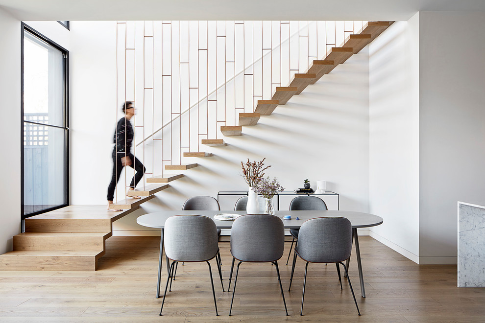 На фото: лестница на больцах, среднего размера в стиле модернизм с деревянными ступенями и металлическими перилами без подступенок с