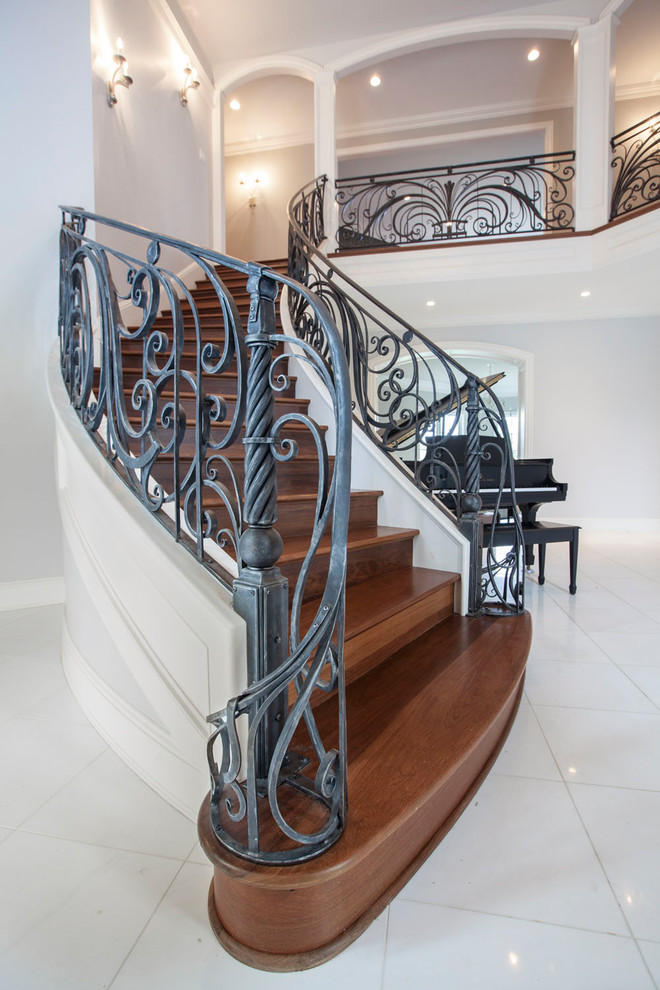Large transitional wooden curved staircase photo in Louisville with wooden risers