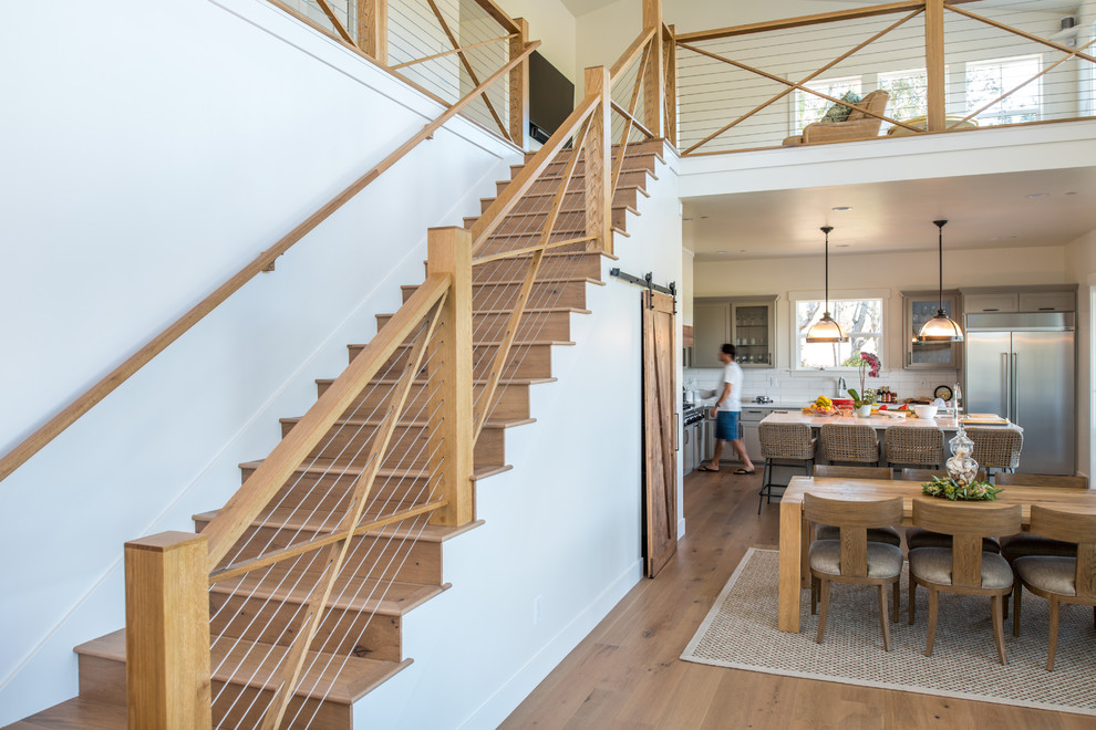 Diseño de escalera recta contemporánea de tamaño medio con escalones de madera, contrahuellas de madera y barandilla de cable