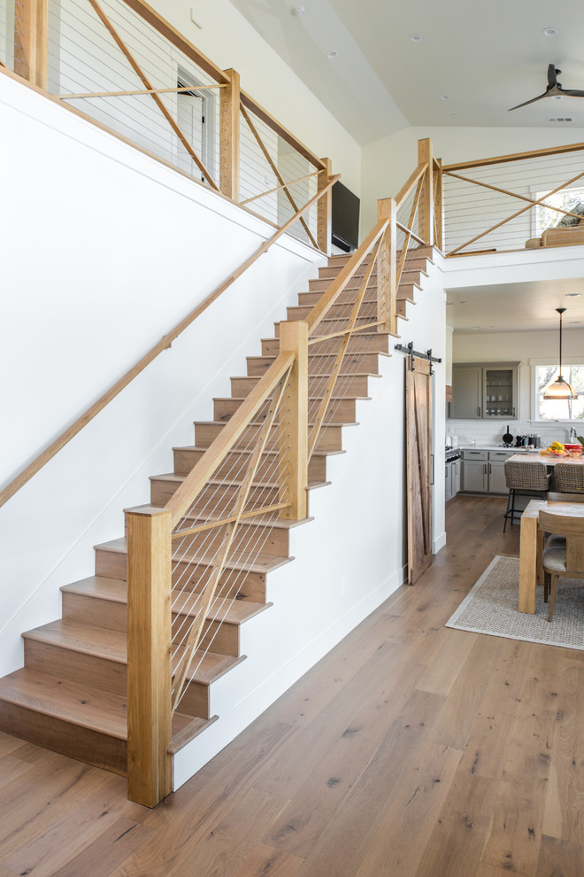 Idée de décoration pour un escalier droit marin de taille moyenne avec des marches en bois, des contremarches en bois et un garde-corps en câble.