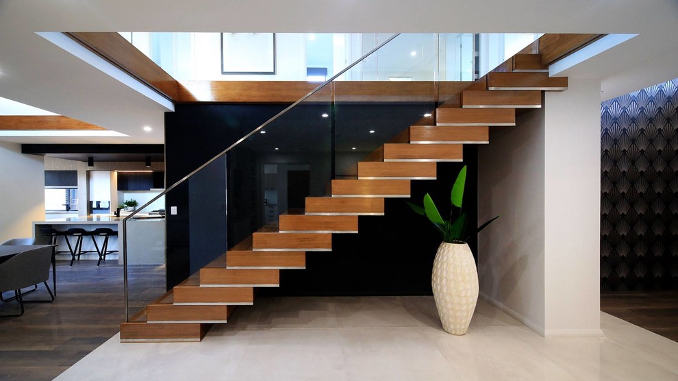 Стильный дизайн: прямая деревянная лестница в современном стиле с деревянными ступенями и стеклянными перилами - последний тренд