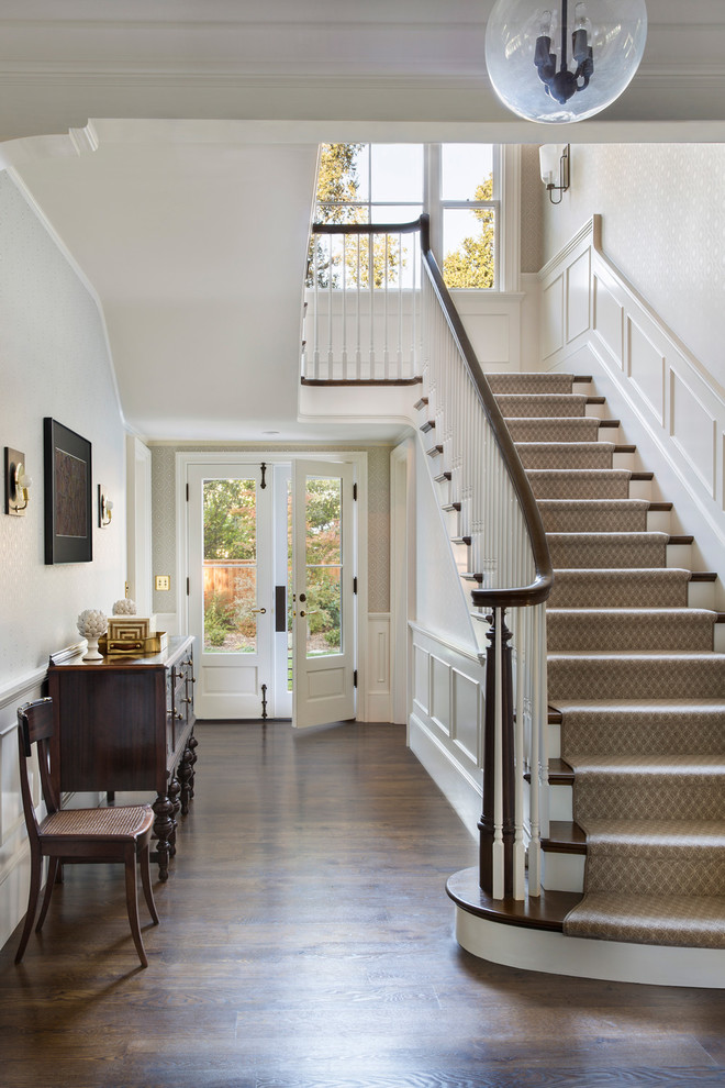 This is an example of a large classic wood u-shaped wood railing staircase in San Francisco with wood risers.