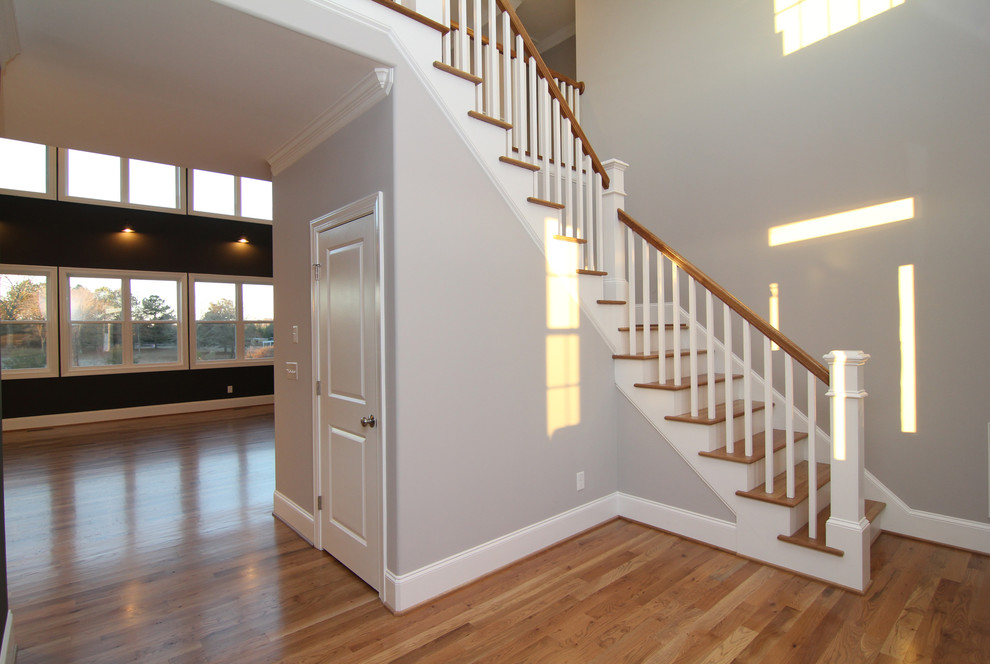 Exemple d'un grand escalier peint tendance en L avec des marches en bois.