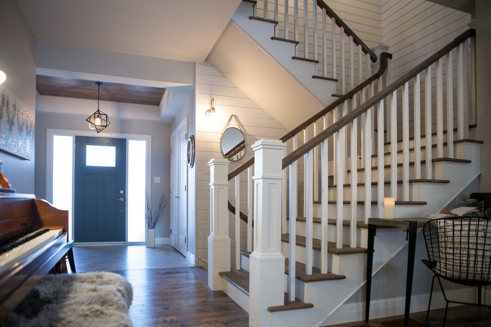 Ejemplo de escalera en L de estilo americano extra grande con escalones de madera y contrahuellas de madera pintada