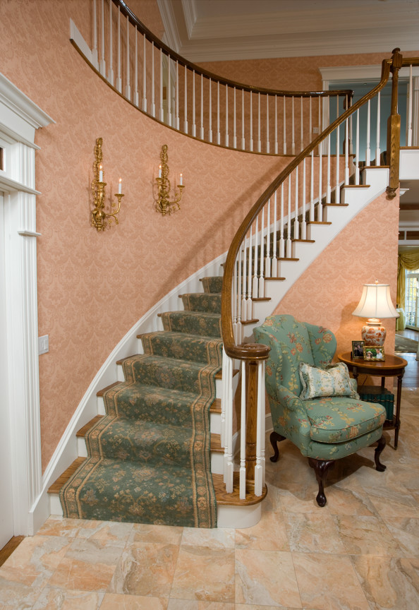 Staircase - traditional wooden curved staircase idea in New York with carpeted risers