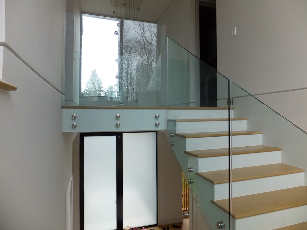 Photo of a medium sized modern wood u-shaped staircase in New York with wood risers.