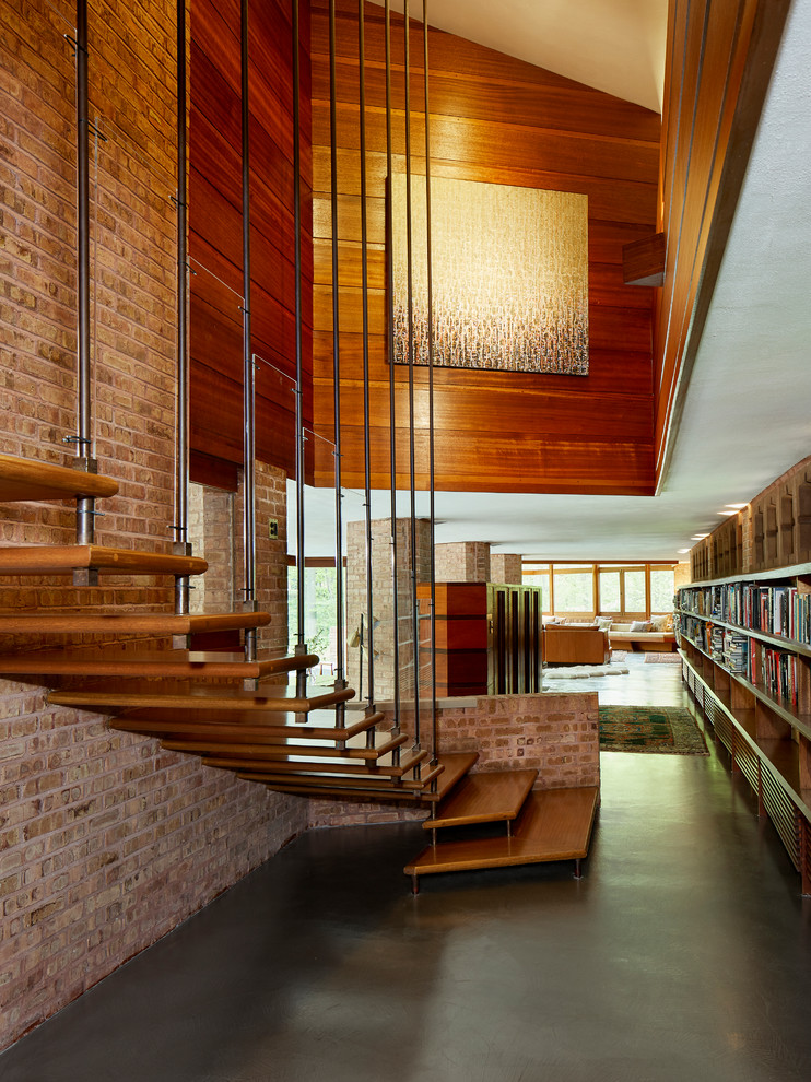 Example of a large mid-century modern wooden floating cable railing staircase design in Chicago