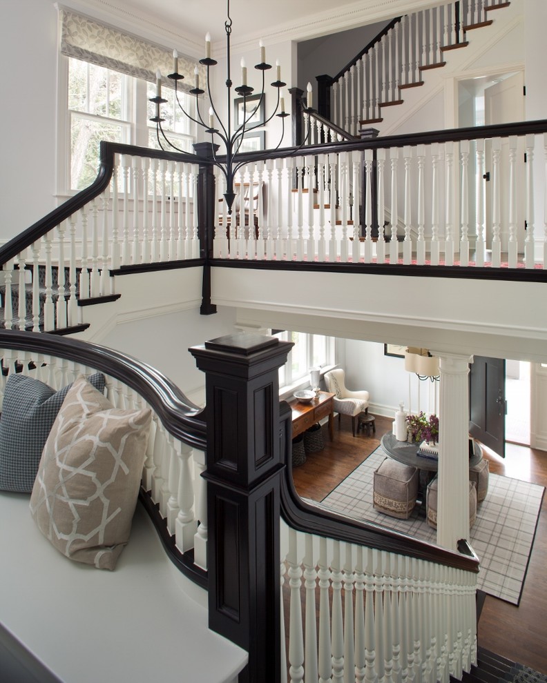 Large traditional carpeted wood railing staircase in Denver with carpeted risers.
