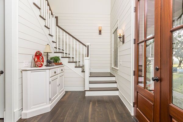 Diseño de escalera en L campestre de tamaño medio con escalones de madera, contrahuellas de madera pintada y barandilla de madera