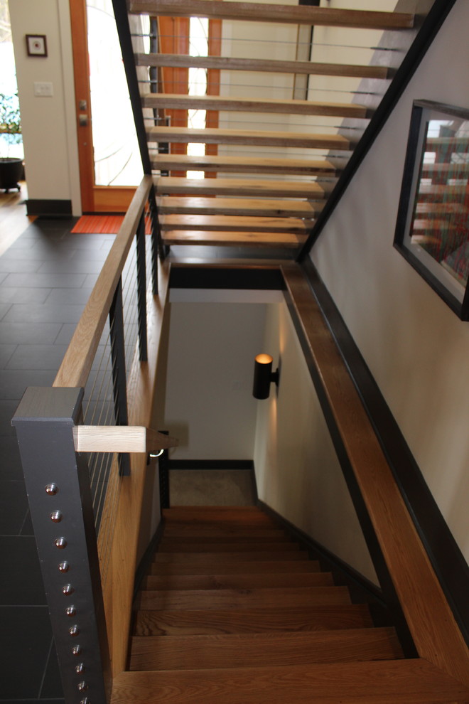 他の地域にあるコンテンポラリースタイルのおしゃれなスケルトン階段 (フローリングの蹴込み板) の写真