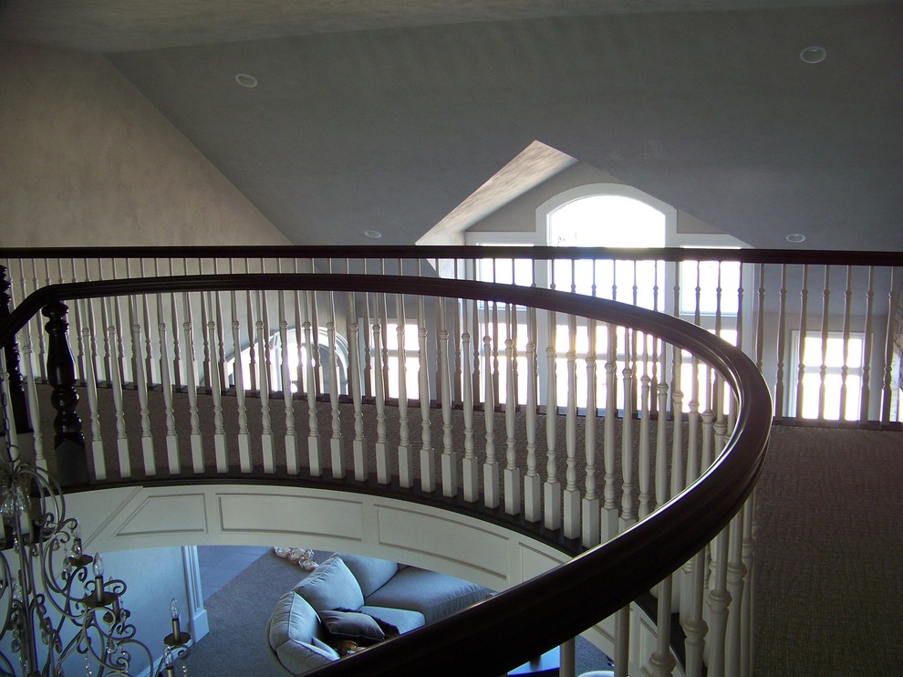 他の地域にある高級な広いトラディショナルスタイルのおしゃれなスケルトン階段 (フローリングの蹴込み板) の写真