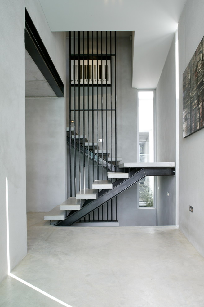 На фото: п-образная лестница в современном стиле с бетонными ступенями без подступенок