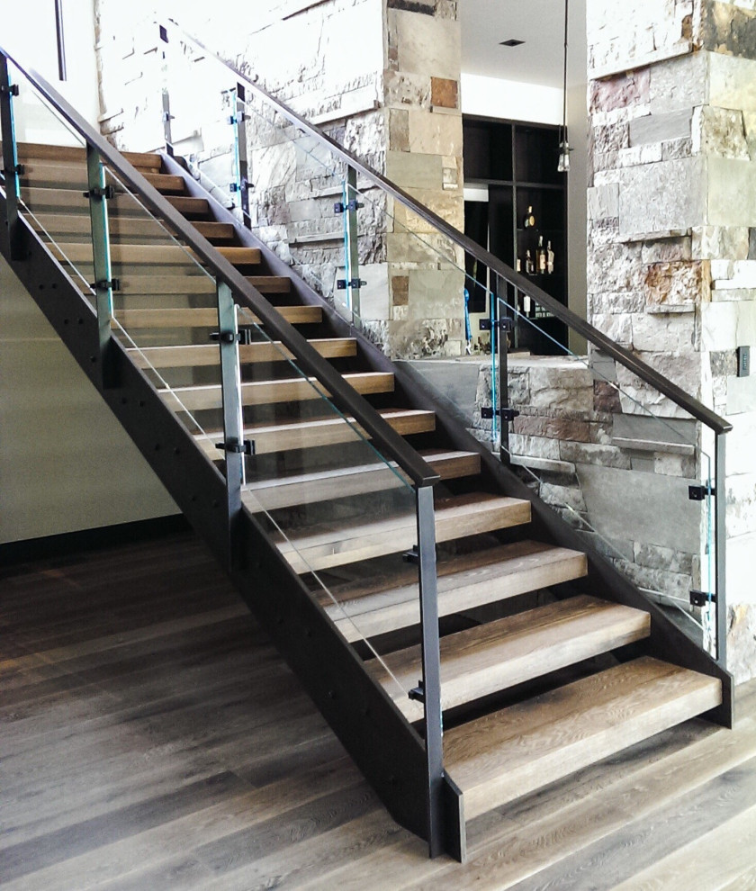 Imagen de escalera actual de tamaño medio sin contrahuella con escalones de madera y barandilla de vidrio