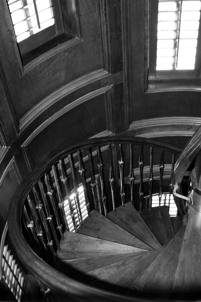Photo of a large traditional wood spiral staircase in Dallas.